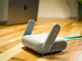 Router Wi-Fi 6 z antenkami, obok laptopa. Czy wiesz, upnp co to? Ułatwia komunikację urządzeń w sieci.