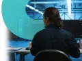 Analityk pracuje nad cyber threat intelligence, analizując dane na monitorach w serwerowni.