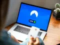 Osoba korzysta z laptopa z włączoną vpn przeglądarką. Na ekranie widnieje logo i komunikat "You are connected".