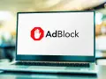Laptop z logo AdBlock. Chcesz wiedzieć, jak wyłączyć adblocka na laptopie?