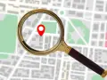 Lupa powiększa mapę z zaznaczonym punktem, sugerując, jak sprawdzić IP komputera.