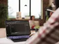 Programista pracuje nad kodem, edycja pliku hosts w tle.