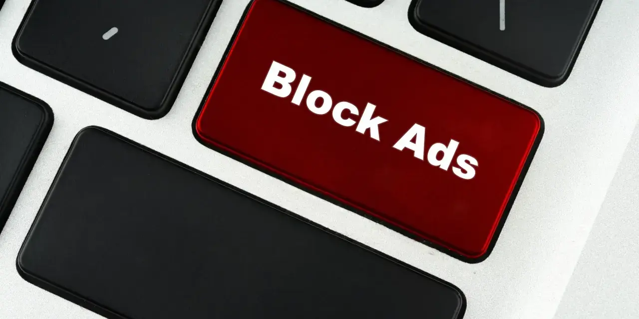 Czerwony klawisz z napisem "Block Ads" symbolizuje, co to jest adblock – narzędzie blokujące reklamy.