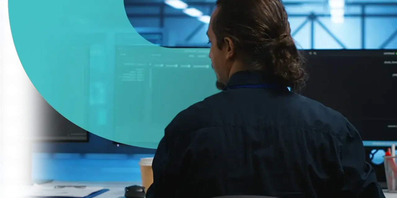 Analityk pracuje nad cyber threat intelligence, analizując dane na monitorach w serwerowni.