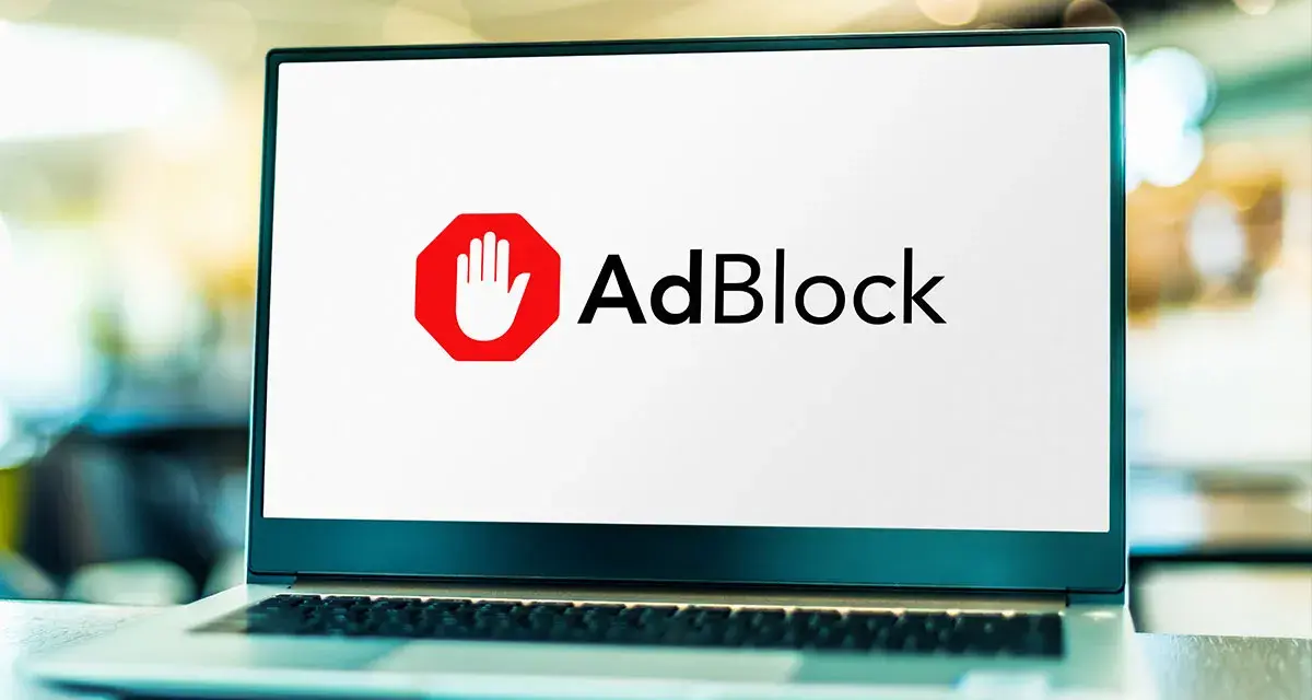 Laptop z logo AdBlock. Chcesz wiedzieć, jak wyłączyć adblocka na laptopie?