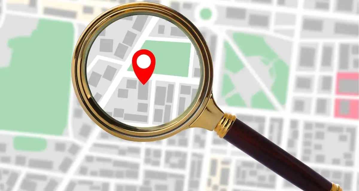 Lupa powiększa mapę z zaznaczonym punktem, sugerując, jak sprawdzić IP komputera.