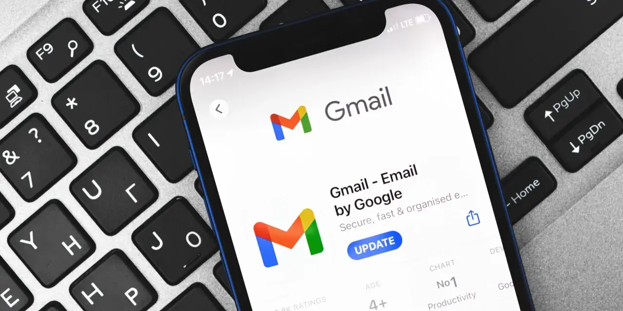 Telefon z aplikacją Gmail na klawiaturze. Dowiedz się, jak zmienić hasło do Gmaila, aby zabezpieczyć swoje konto.