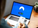 Osoba korzysta z laptopa z włączoną vpn przeglądarką. Na ekranie widnieje logo i komunikat "You are connected".