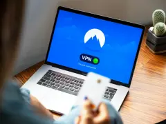 Osoba korzysta z laptopa z włączoną vpn przeglądarką. Na ekranie widnieje logo i komunikat "You are connected".