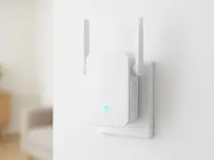 Biały wzmacniacz Wi-Fi z antenkami, podłączony do gniazdka. Pokazuje, jak działa wzmacniacz Wi-Fi, rozszerzając zasięg sieci.