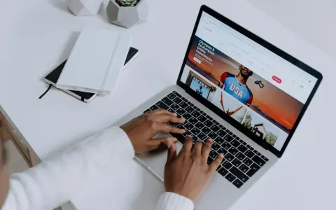 Osoba pisze na klawiaturze laptopa, na ekranie którego widać stronę z ofertami podróży. Przeglądarki internetowe otwierają świat możliwości.