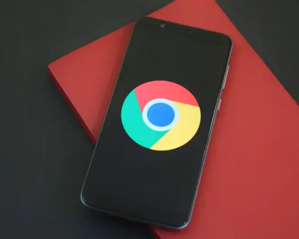 Smartfon z logo Chrome. Dowiedz się, jak wylaczyc historie przegladania Chrome, aby zachować prywatność.