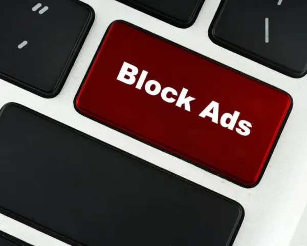 Czerwony klawisz z napisem "Block Ads" symbolizuje, co to jest adblock – narzędzie blokujące reklamy.