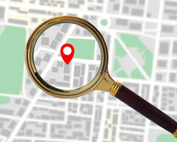 Lupa powiększa mapę z zaznaczonym punktem, sugerując, jak sprawdzić IP komputera.