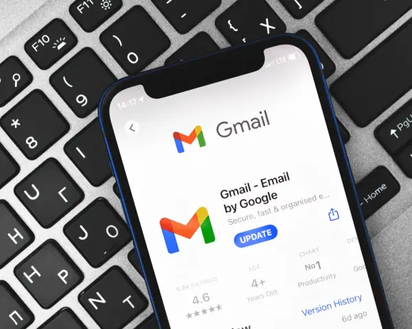 Telefon z aplikacją Gmail na klawiaturze. Dowiedz się, jak zmienić hasło do Gmaila, aby zabezpieczyć swoje konto.