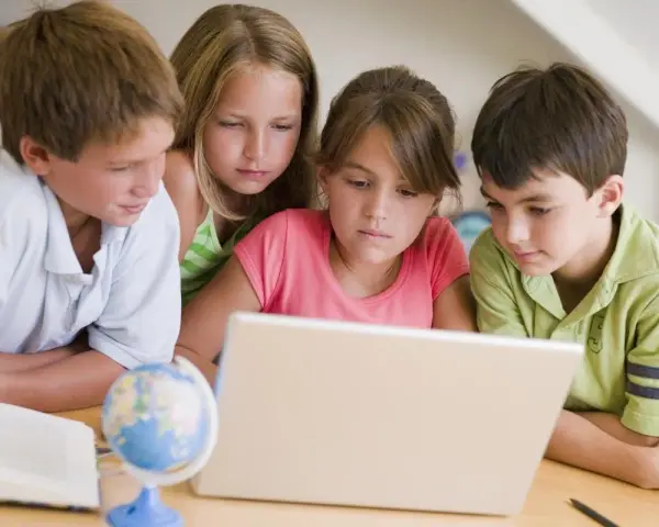 Dzieci uczą się, jak sprawdzić swoją lokalizację na mapie świata, korzystając z laptopa.