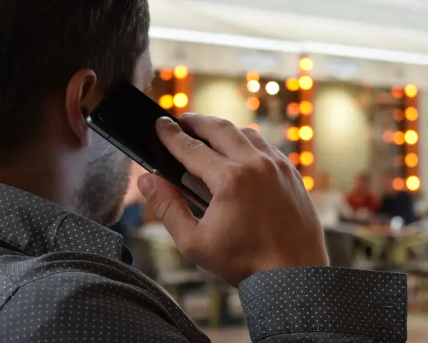 Mężczyzna rozmawia przez telefon, zastanawiając się, co to jest catfishing i czy sam nie jest jego ofiarą.