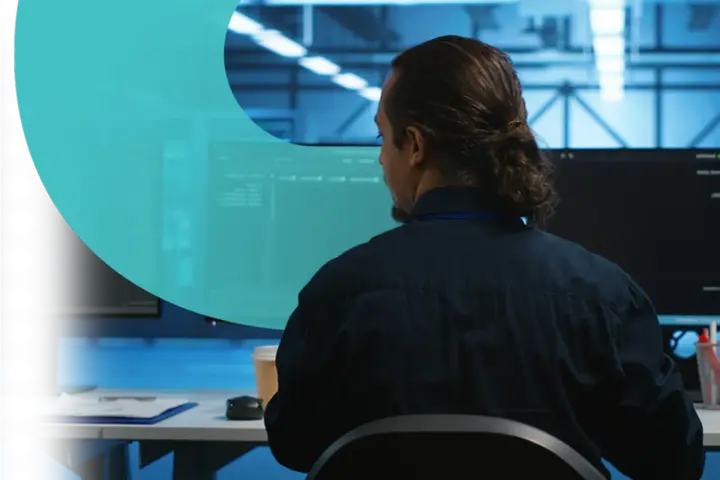 Analityk pracuje nad cyber threat intelligence, analizując dane na monitorach w serwerowni.