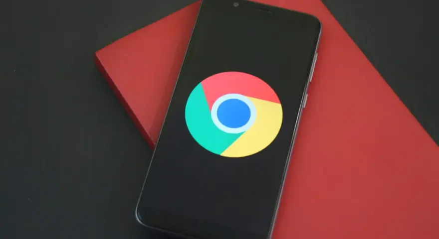 Smartfon z logo Chrome. Dowiedz się, jak wylaczyc historie przegladania Chrome, aby zachować prywatność.