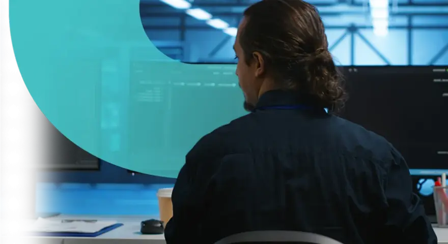 Analityk pracuje nad cyber threat intelligence, analizując dane na monitorach w serwerowni.