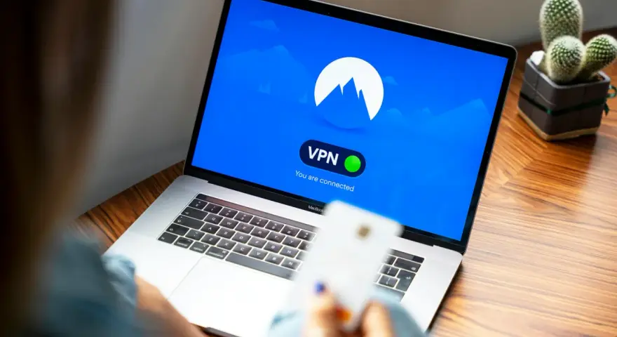 Osoba korzysta z laptopa z włączoną vpn przeglądarką. Na ekranie widnieje logo i komunikat "You are connected".