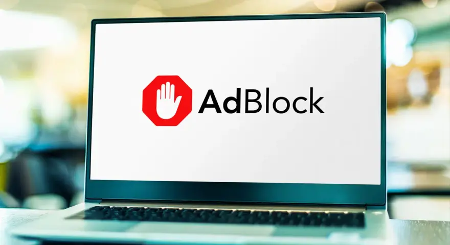 Laptop z logo AdBlock. Chcesz wiedzieć, jak wyłączyć adblocka na laptopie?