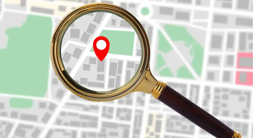Lupa powiększa mapę z zaznaczonym punktem, sugerując, jak sprawdzić IP komputera.