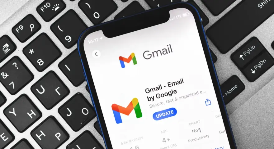 Telefon z aplikacją Gmail na klawiaturze. Dowiedz się, jak zmienić hasło do Gmaila, aby zabezpieczyć swoje konto.
