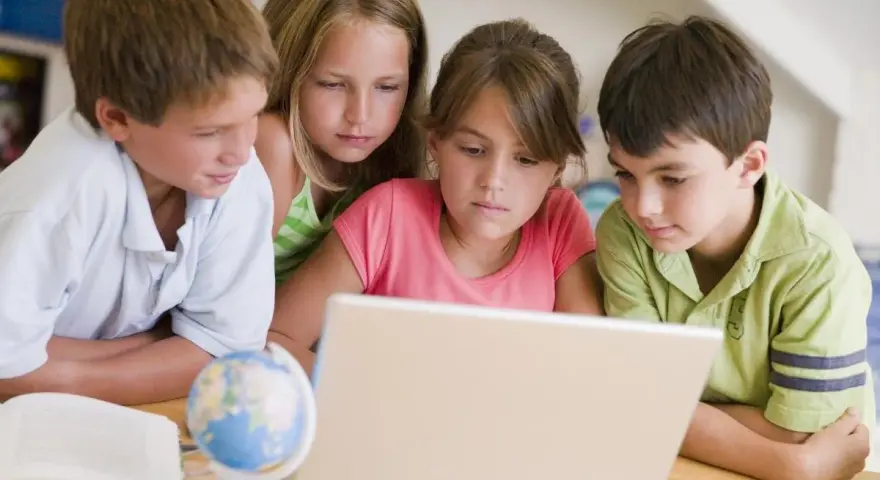 Dzieci uczą się, jak sprawdzić swoją lokalizację na mapie świata, korzystając z laptopa.