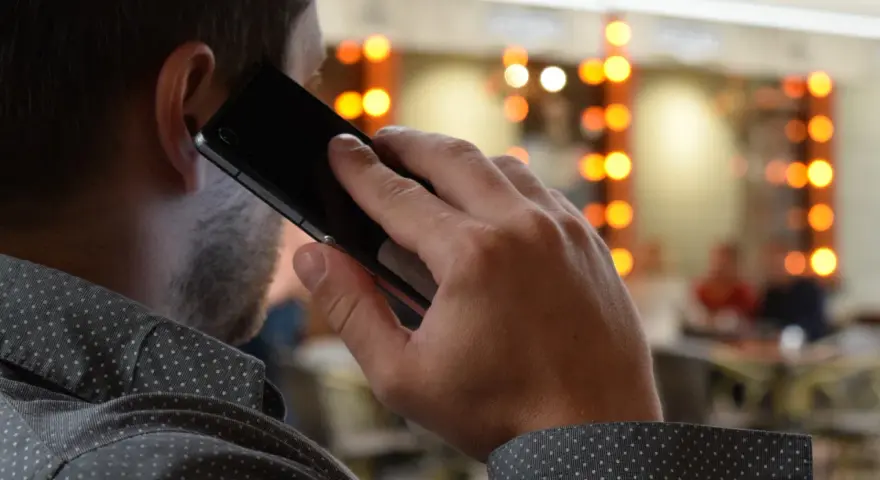 Mężczyzna rozmawia przez telefon, zastanawiając się, co to jest catfishing i czy sam nie jest jego ofiarą.