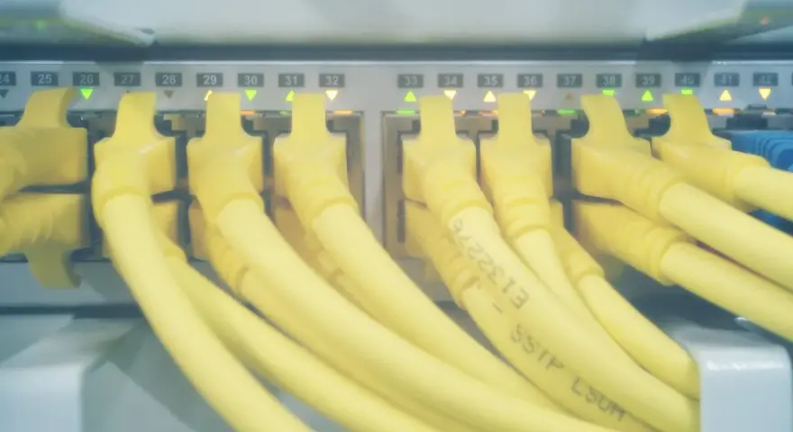 Żółte kable sieciowe podłączone do portów serwera. Zielone i pomarańczowe diody sygnalizują aktywność, a numery portów od 24 do 42 wskazują, które hosts windows są podłączone.