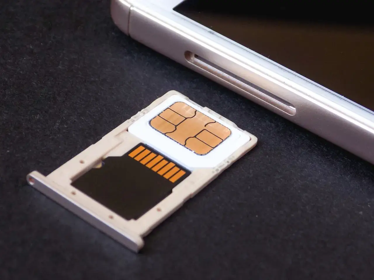 Taca SIM z kartą pamięci obok telefonu. Przygotowanie do sim swapping.
