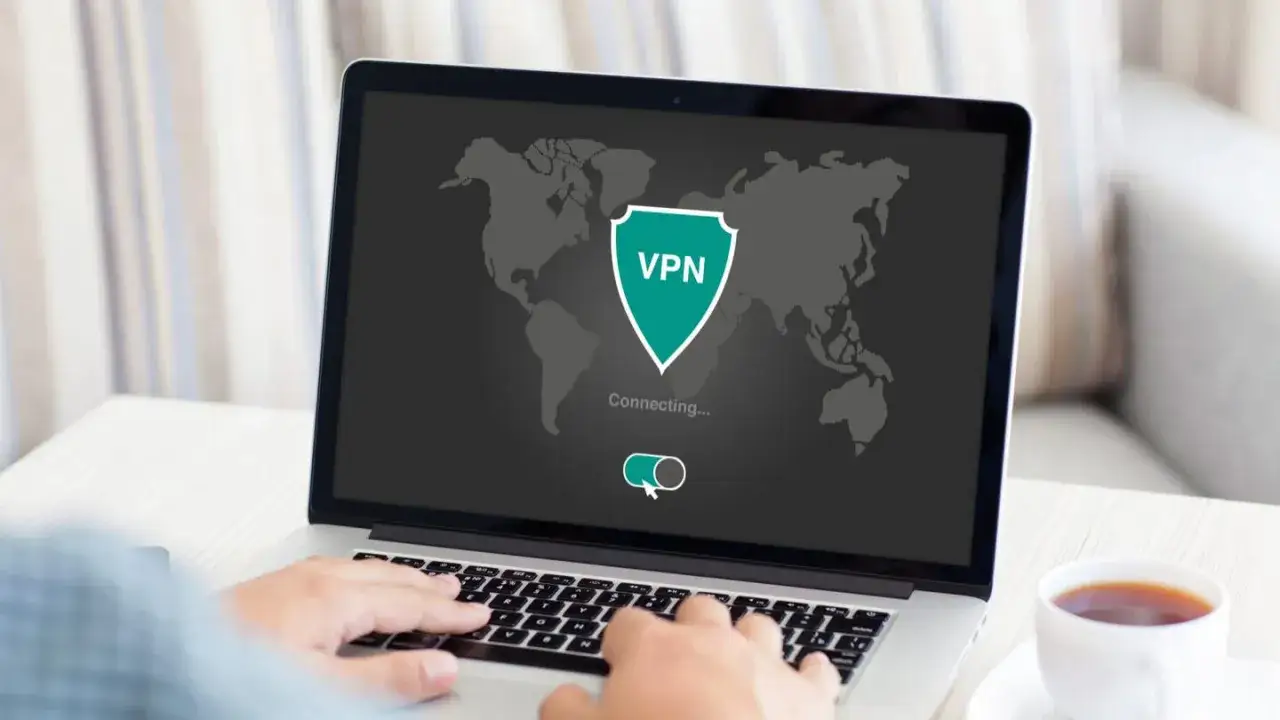 Na ekranie laptopa mapa świata i symbol VPN. Użytkownik uczy się, jak używać VPN, by połączyć się z siecią.