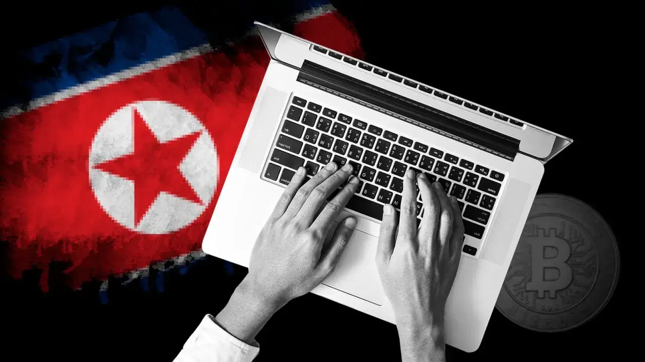 Ręce piszą na laptopie na tle flagi Korei Północnej i monety Bitcoin. Sugeruje to działania grupy Lazarus.